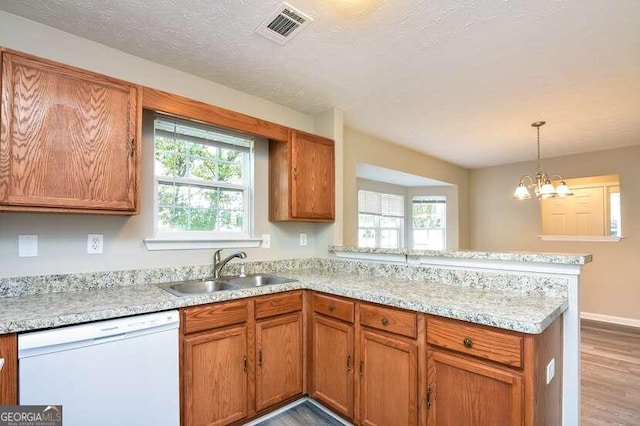 kitchen with white dishwasher, an inviting chandelier, sink, and light hardwood / wood-style flooring