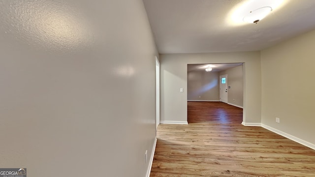 corridor with light hardwood / wood-style floors