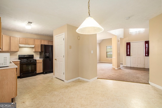 kitchen featuring a textured ceiling, light brown cabinets, black appliances, and decorative light fixtures