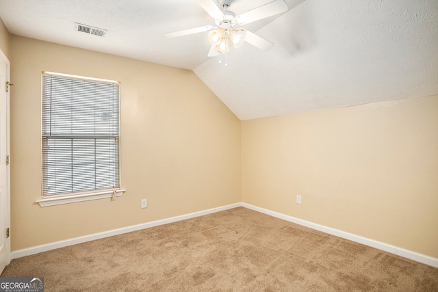 additional living space featuring light carpet, vaulted ceiling, and ceiling fan