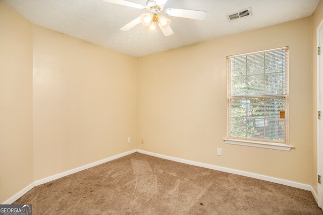 carpeted spare room featuring a textured ceiling and ceiling fan