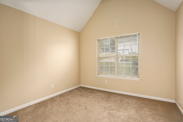 carpeted spare room featuring high vaulted ceiling