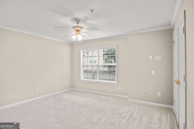 spare room with light colored carpet, ceiling fan, and crown molding