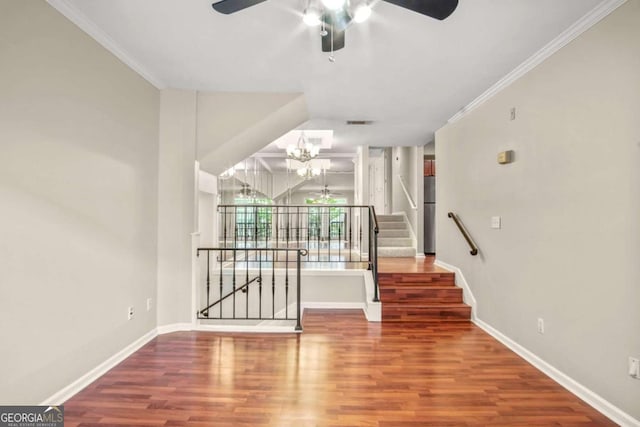 interior space featuring ceiling fan with notable chandelier, wood-type flooring, and crown molding