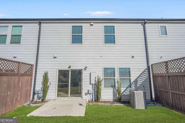 rear view of property featuring a yard, a patio, and cooling unit