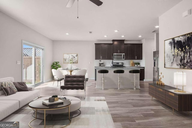 living room with ceiling fan and light hardwood / wood-style floors