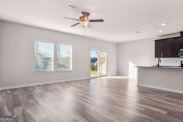 unfurnished living room featuring ceiling fan and wood-type flooring