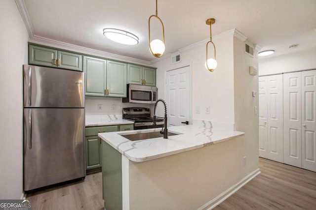 kitchen featuring kitchen peninsula, light stone counters, stainless steel appliances, green cabinetry, and hanging light fixtures