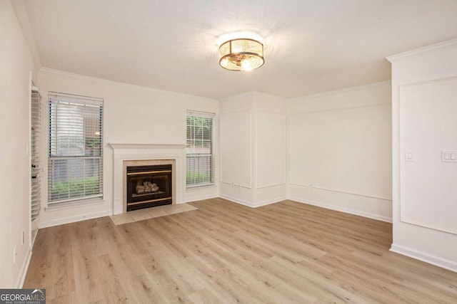 unfurnished living room featuring a fireplace, light wood-type flooring, and ornamental molding