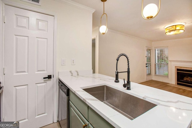 kitchen with sink, dishwasher, hanging light fixtures, crown molding, and green cabinetry