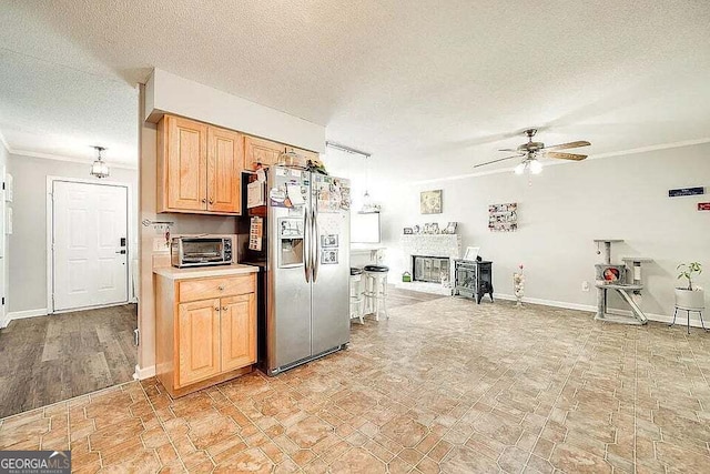 kitchen with ornamental molding, a textured ceiling, ceiling fan, pendant lighting, and stainless steel fridge with ice dispenser