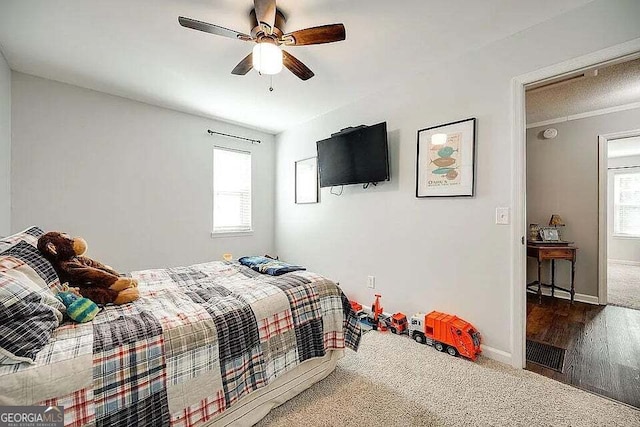 bedroom featuring hardwood / wood-style flooring, multiple windows, and ceiling fan