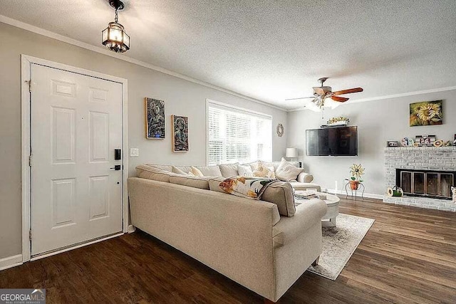 living room featuring a textured ceiling, dark hardwood / wood-style flooring, ceiling fan, and crown molding