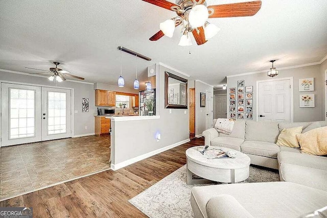 living room with french doors, wood-type flooring, a textured ceiling, and ornamental molding