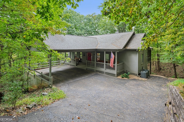 single story home featuring a porch, central AC, and a carport