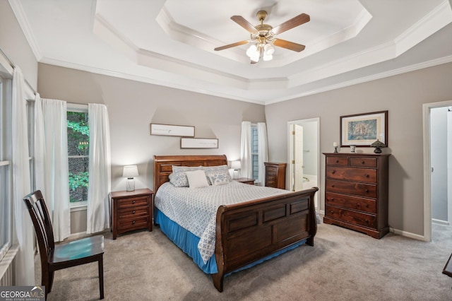 bedroom with connected bathroom, ceiling fan, crown molding, light colored carpet, and a tray ceiling