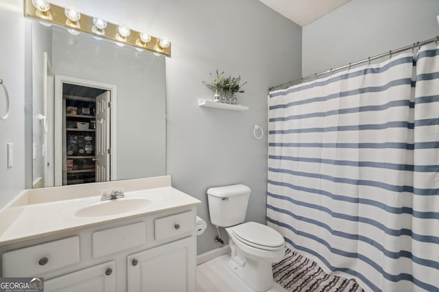 bathroom featuring a shower with shower curtain, a textured ceiling, vanity, and toilet