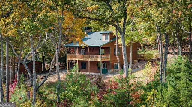 rear view of house with a storage unit and a deck