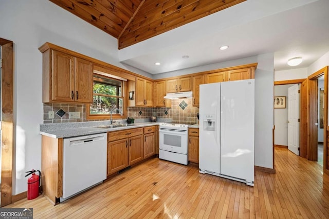 kitchen with backsplash, white appliances, vaulted ceiling, sink, and light hardwood / wood-style flooring