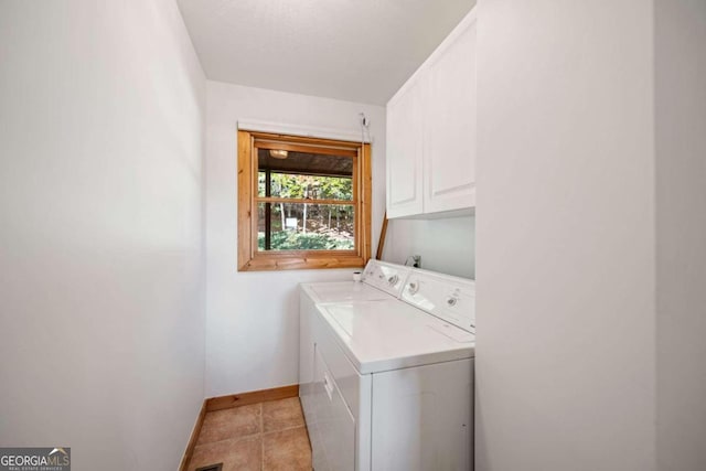 laundry area featuring cabinets, light tile patterned floors, and washing machine and dryer