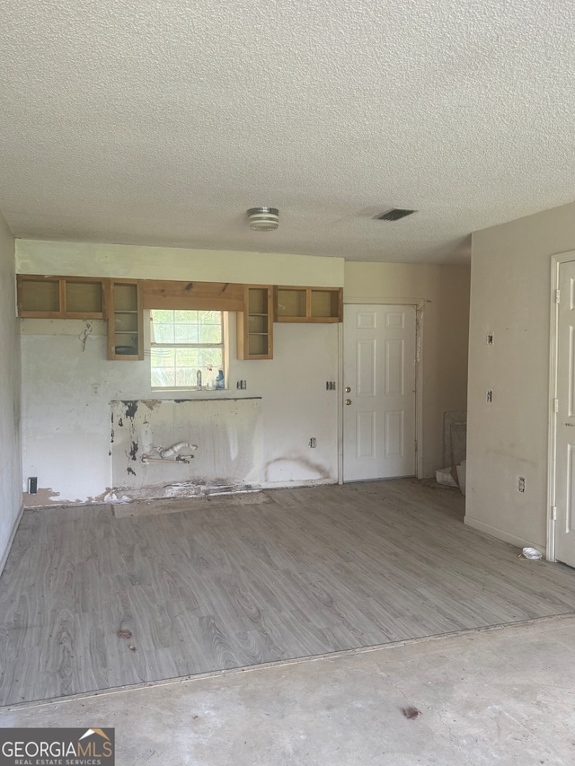 kitchen featuring hardwood / wood-style floors and a textured ceiling