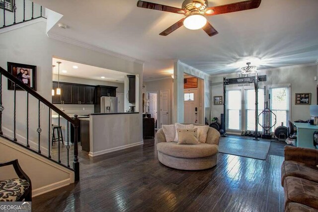 living room featuring a fireplace, dark hardwood / wood-style flooring, ceiling fan, and ornamental molding