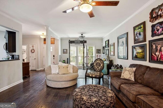 living room featuring dark hardwood / wood-style flooring, a stone fireplace, a wealth of natural light, and ornamental molding