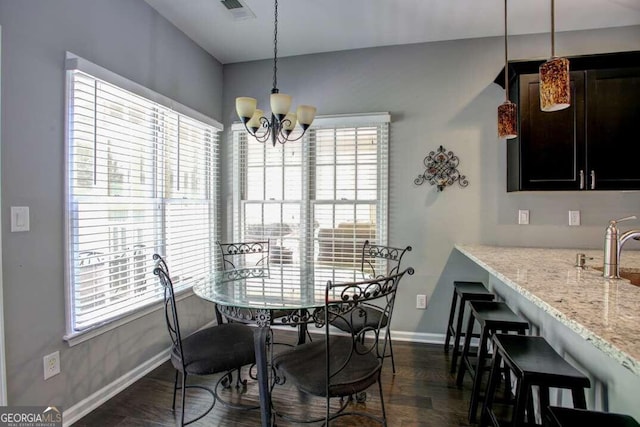 dining space featuring plenty of natural light, dark hardwood / wood-style floors, and a notable chandelier