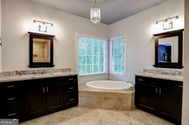 bathroom with vanity, tile patterned floors, a notable chandelier, and tiled tub