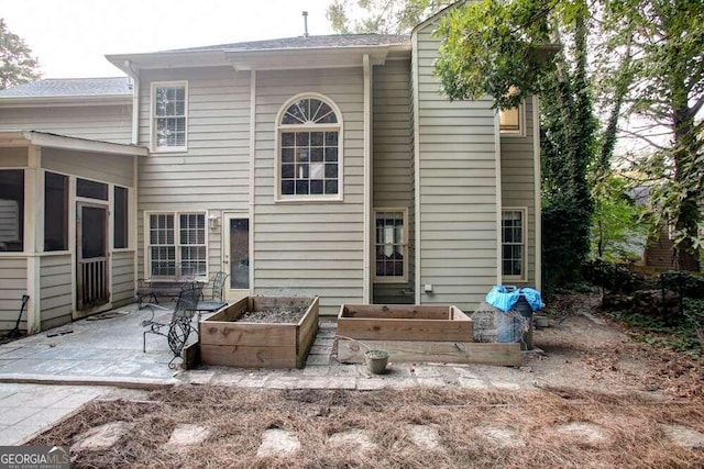 rear view of property with a sunroom and a patio