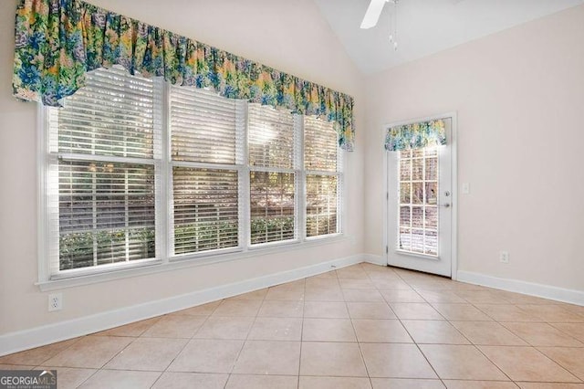 tiled spare room featuring vaulted ceiling and ceiling fan