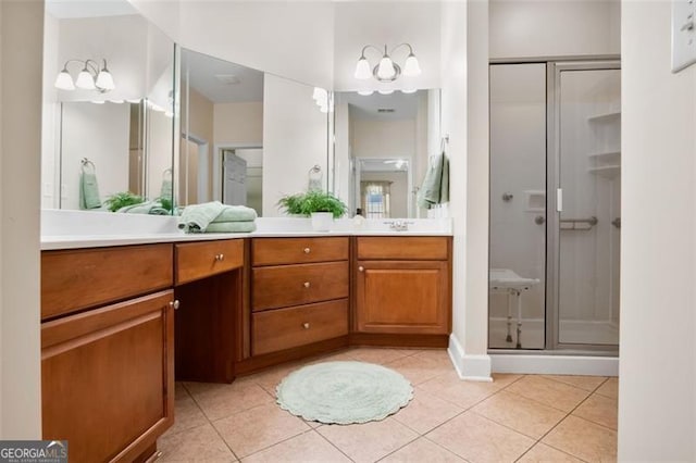 bathroom with tile patterned flooring, vanity, and a shower with door