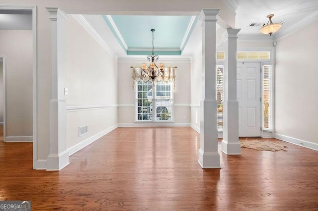 foyer featuring wood-type flooring, crown molding, a tray ceiling, and a chandelier