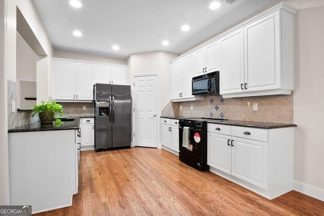 kitchen featuring backsplash, dark stone counters, black appliances, white cabinets, and light hardwood / wood-style flooring