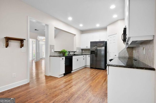 kitchen featuring backsplash, light hardwood / wood-style floors, white cabinetry, and black appliances