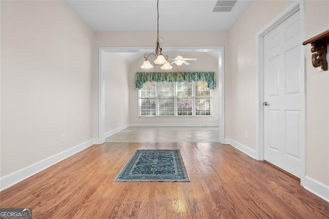 unfurnished dining area featuring hardwood / wood-style floors and an inviting chandelier