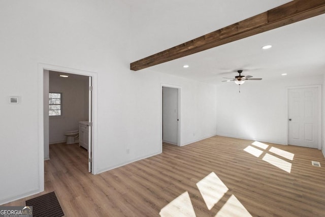 unfurnished living room featuring beamed ceiling, light hardwood / wood-style floors, and ceiling fan