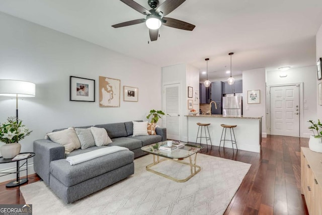 living room with ceiling fan and dark hardwood / wood-style flooring