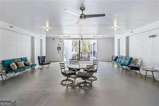 dining space with ceiling fan and concrete floors