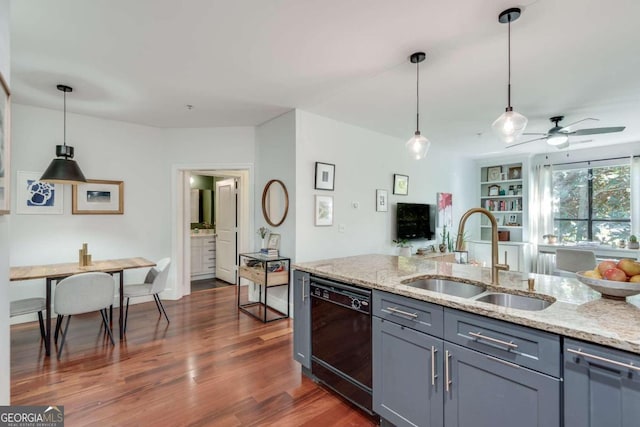 kitchen with dishwasher, light stone countertops, dark wood-type flooring, and sink