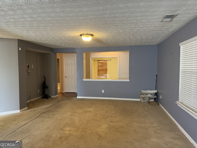 carpeted spare room featuring a textured ceiling