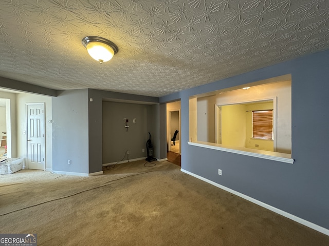 carpeted spare room featuring a textured ceiling