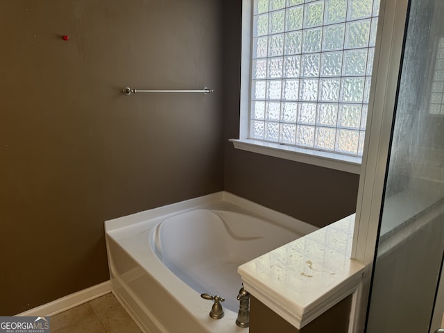 bathroom with tile patterned floors, plenty of natural light, and a bath