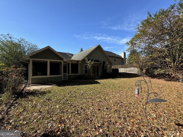 back of house featuring a yard and a sunroom