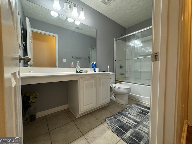 full bathroom with vanity, tile patterned floors, combined bath / shower with glass door, toilet, and a textured ceiling