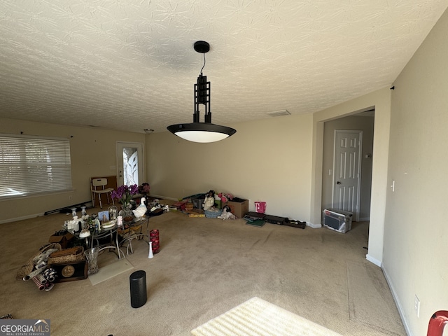 unfurnished dining area featuring a textured ceiling and carpet floors