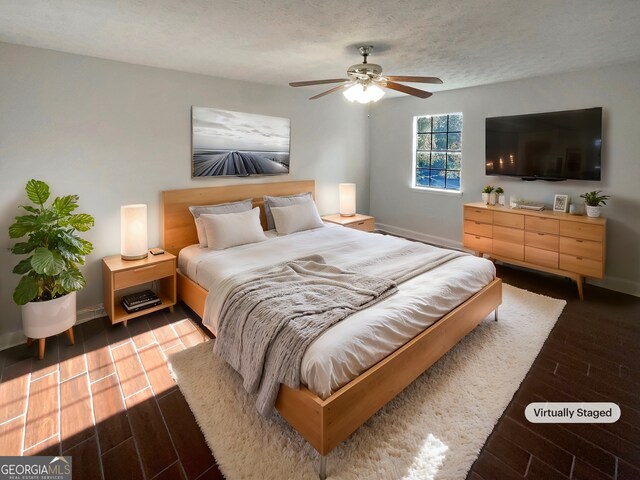 bedroom with hardwood / wood-style flooring, ceiling fan, and a textured ceiling