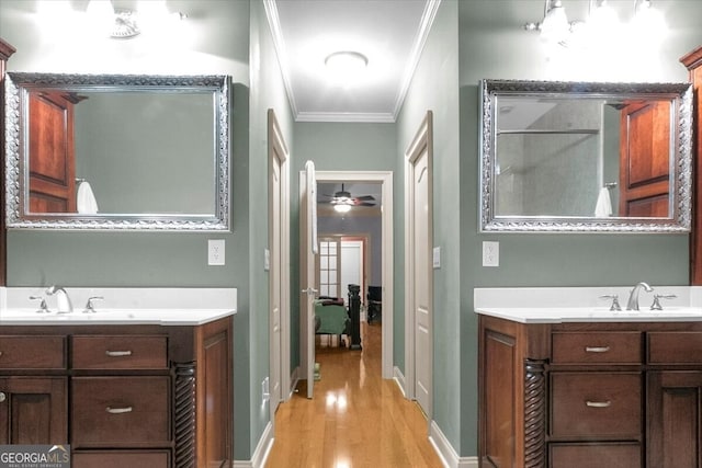 bathroom with hardwood / wood-style flooring, ceiling fan, ornamental molding, and vanity