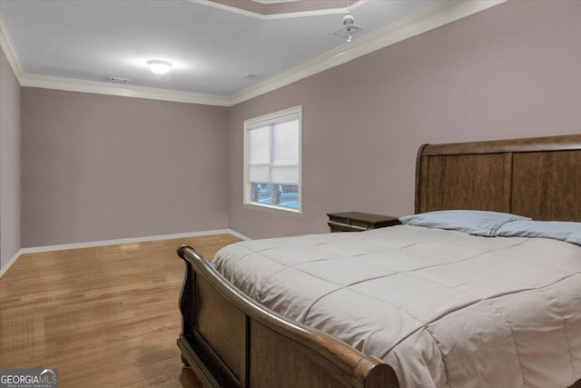 bedroom featuring crown molding and light hardwood / wood-style flooring