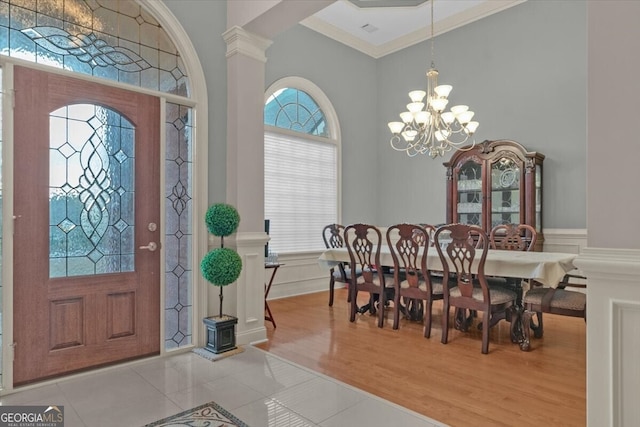 entryway featuring light hardwood / wood-style floors, ornamental molding, and an inviting chandelier